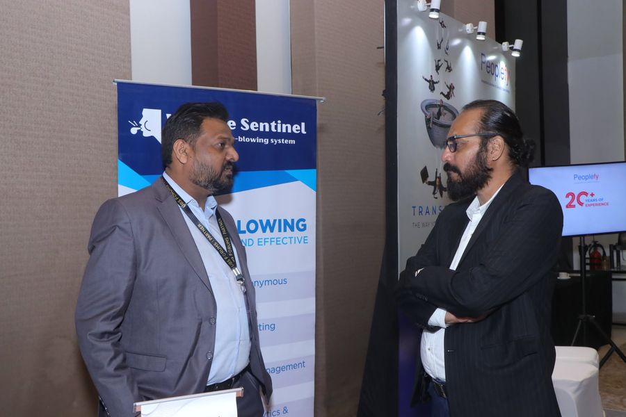 The WhistleSentinel team engaging with attendees beside the event booth